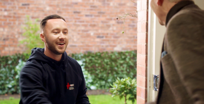 An approved contractor, happily shaking hands with potential customer outside of the household.