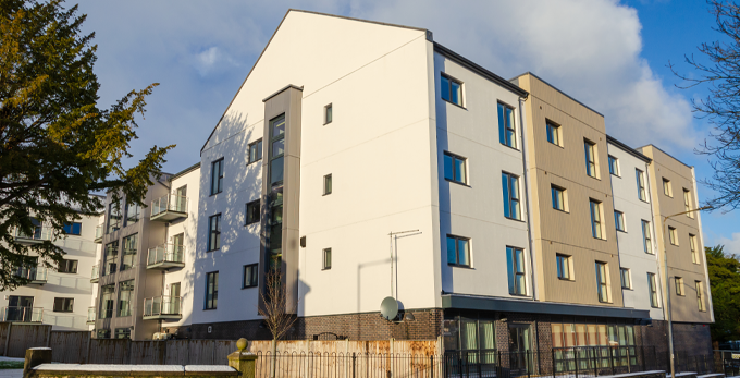 The front of a set of housing association flats on a sunny day.