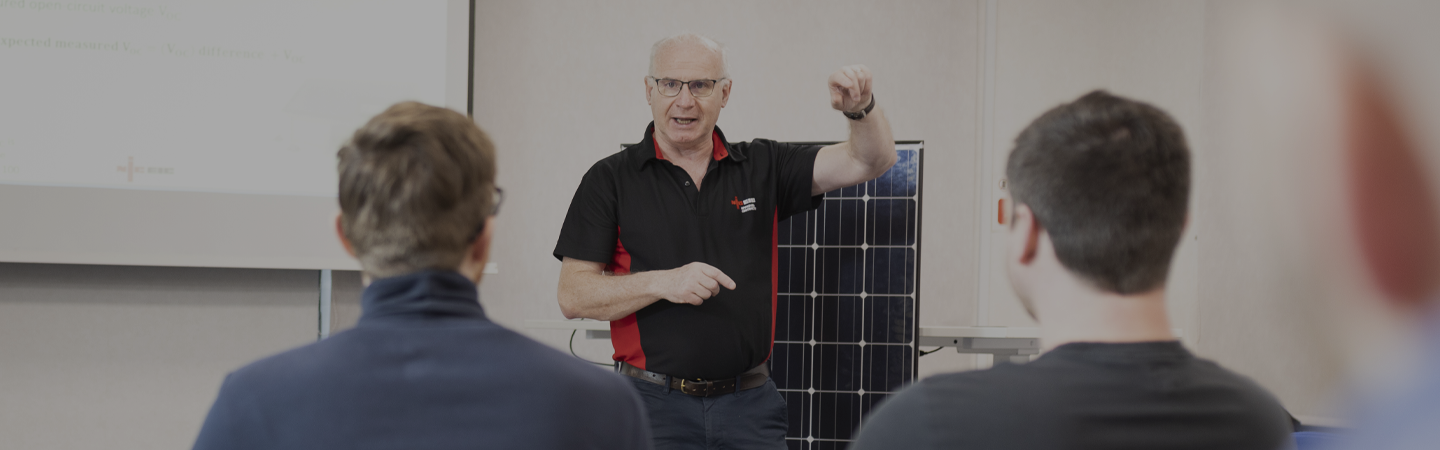 NICEIC approved contractor leading a training course on solar energy, to a class room of tradesmen.