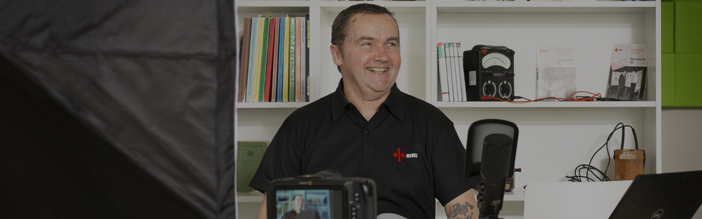 An NICEIC specialist, sat down on set, ready to begin filming an online webinar.